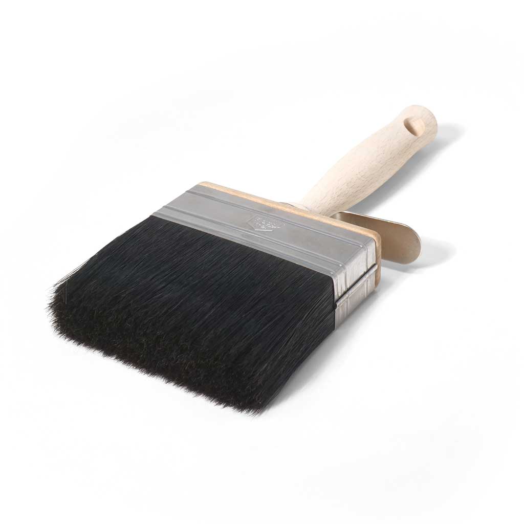 Paint brush with black bristles and a wooden handle on a white background