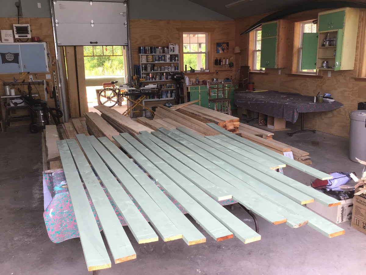 Freshly painted trim boards drying indoors in a workshop
