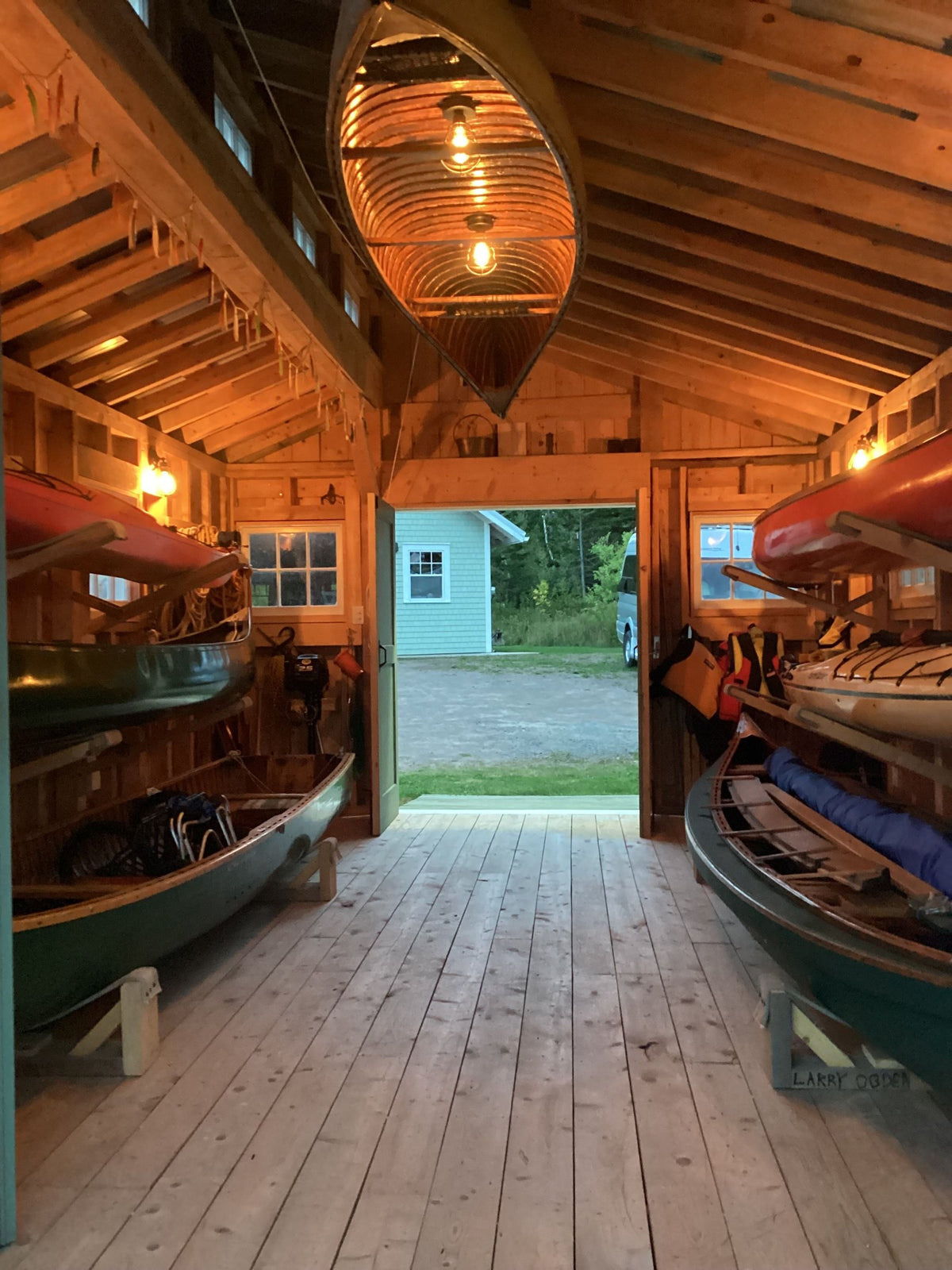 Inside the boat shed, canoes stored along the walls and from the rafters