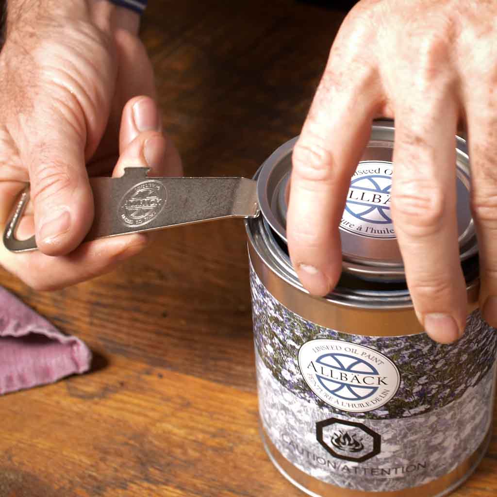 Person using the Allbäck Paint Can Opener on a can of Allbäck Linseed Oil Paint.