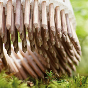 Coil of LIGNOLOC® Wooden Nails on a bed of green spruce tips, turned up to show the pointed tips of the wooden nails.