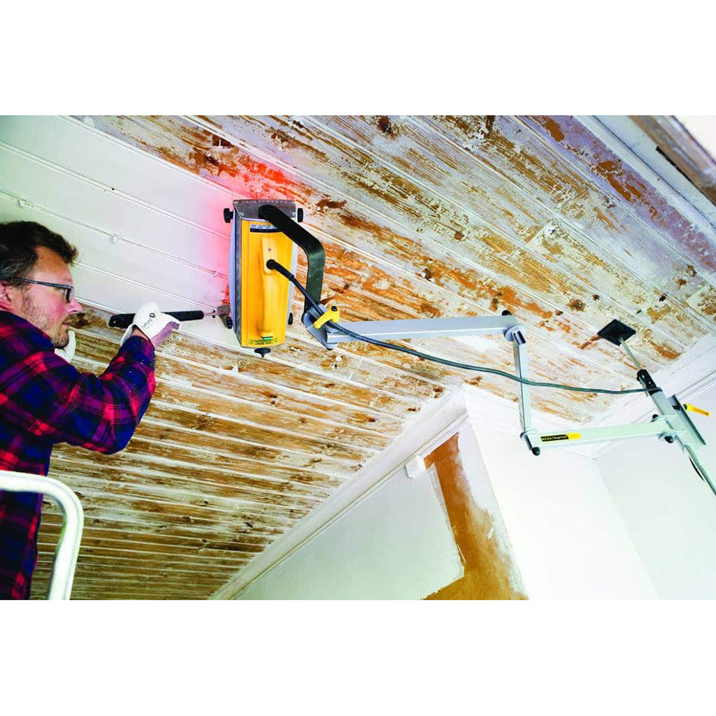Speedheater Classic Hands-free Arm holds the Speedheater Standard Infrared Paint Remover suspended against tongue and groove ceiling. The heater softens paint in one area, while the paint is being scraped from another.