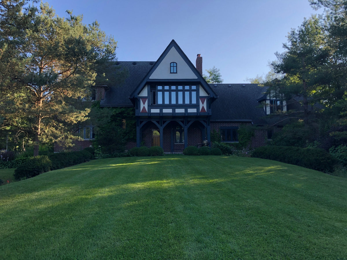 Tudor-style house with painted timber gables seen across the lawn