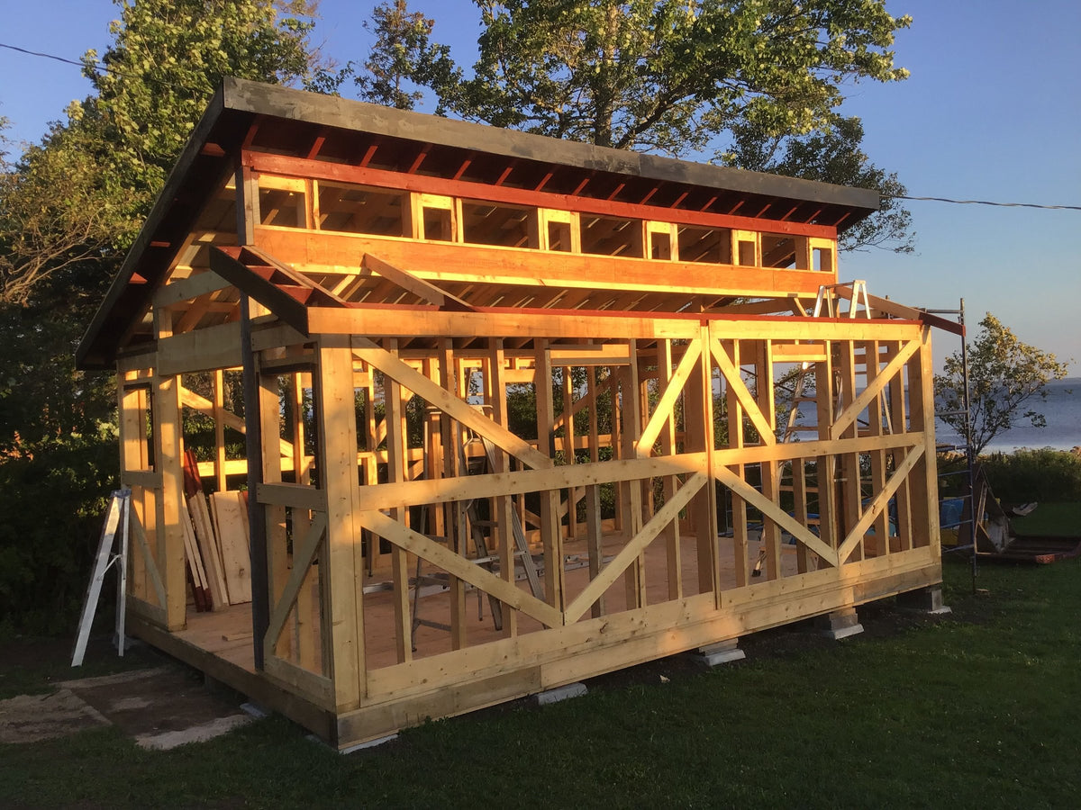 Timber frame of the boat shed under construction beside the water