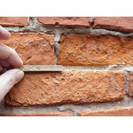 Take out a sample piece from the Ecologic Lime Mortar Kit for a side-by-side comparison to the existing old mortar.